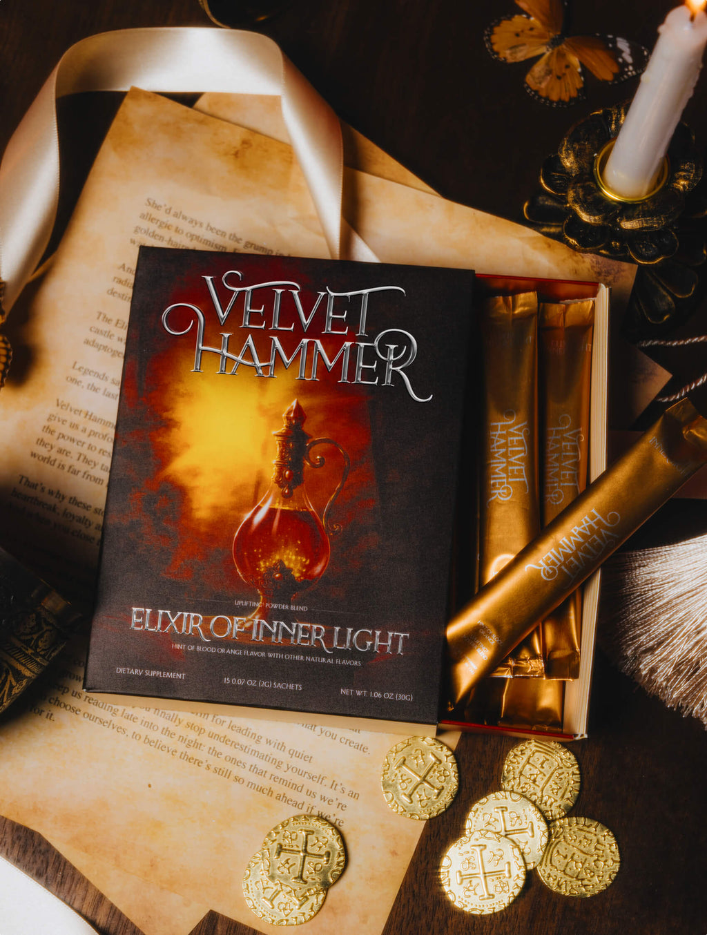 Elixir of Inner Light - Velvet Hammer - Book titled 'Velvet Hammer: Elixir of Inner Light' with gold packaging and coins on a dark surface.
