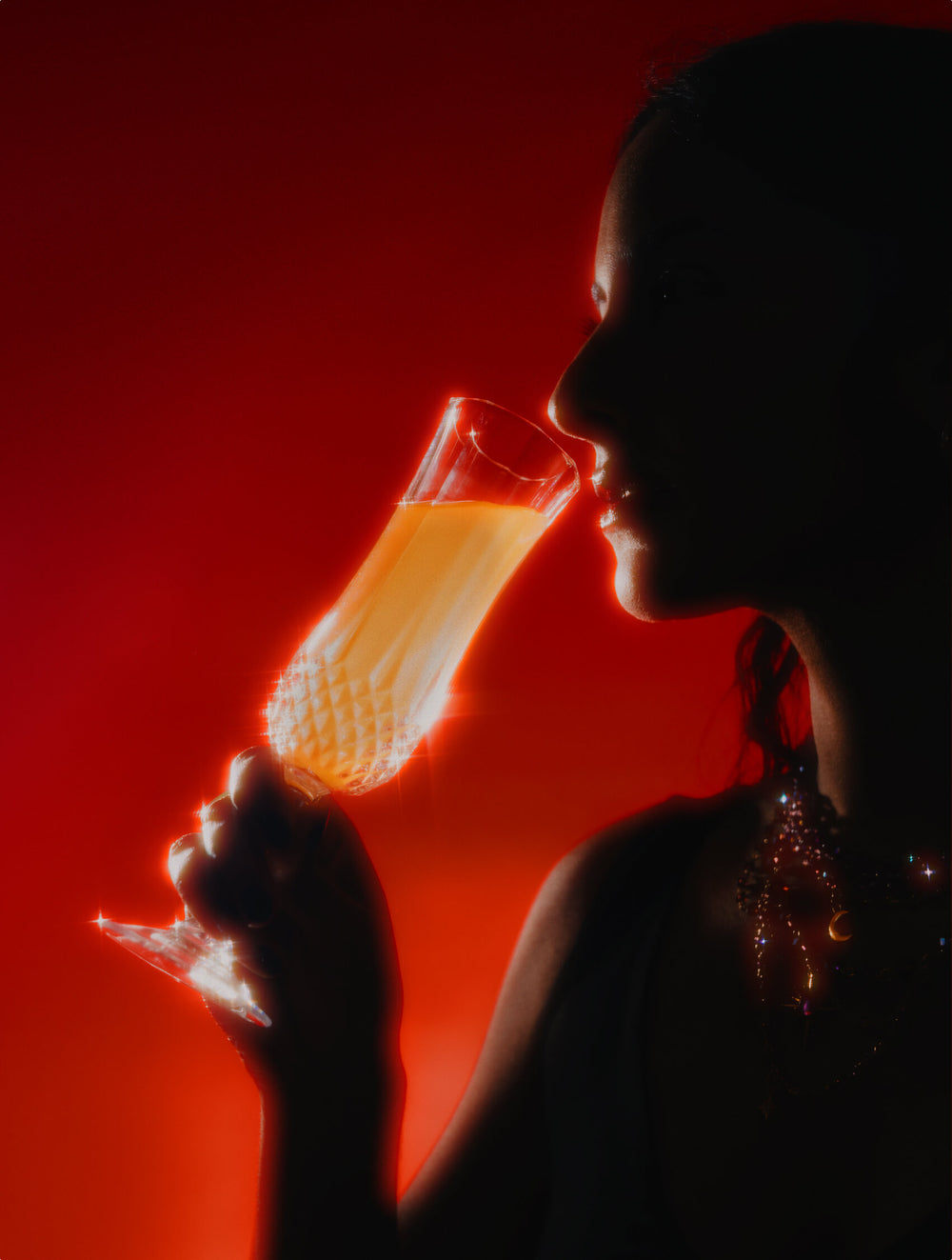Elixir of Inner Light - Velvet Hammer - Silhouette of a person drinking the Elixir of Inner Light  from a glass against a red background