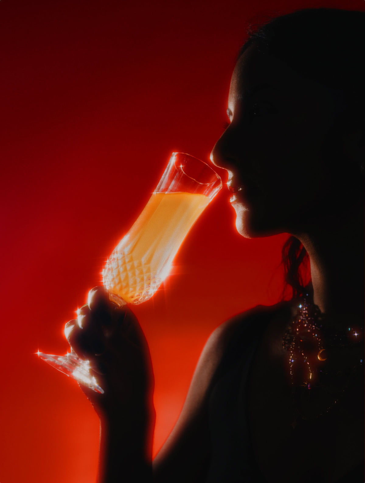 Elixir of Inner Light - Velvet Hammer - Silhouette of a person drinking the Elixir of Inner Light  from a glass against a red background